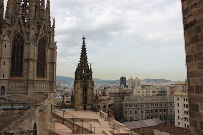 Buildings in city against cloudy sky