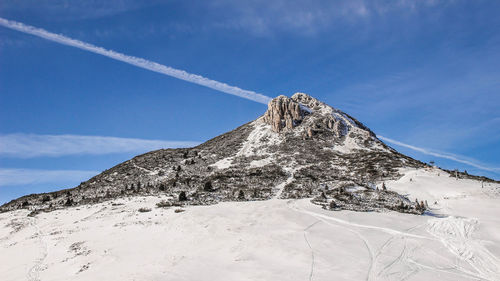 Low angle view of snowcapped mountain against sky