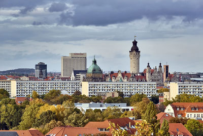 Buildings in city against cloudy sky