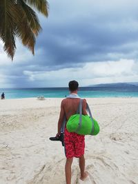 Rear view of friends standing on beach