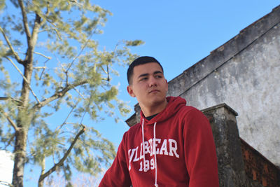 Low angle view of young man against house