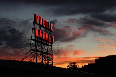 Low angle view of silhouette text against dramatic sky during sunset