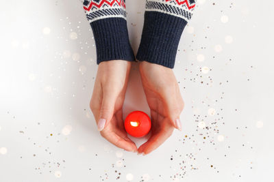 Beautiful female hands with red burning candle. warmth and love concept