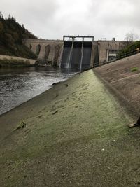 View of dam by river against sky