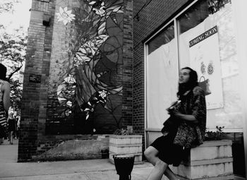 Woman standing against building in city