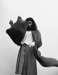 Portrait of woman wearing scarf while standing against wall