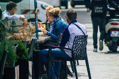 People sitting on chair in city