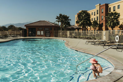 Young preschool age girl swimming in pool on vacation in palm springs