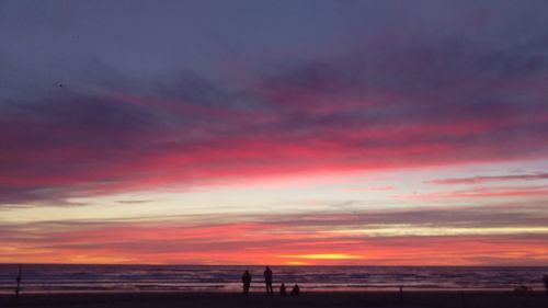 Scenic view of sea against dramatic sky during sunset