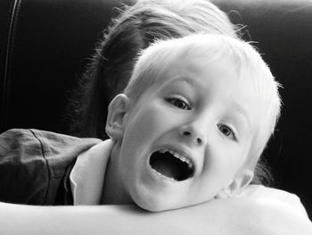 Portrait of cheerful boy with mouth open at home