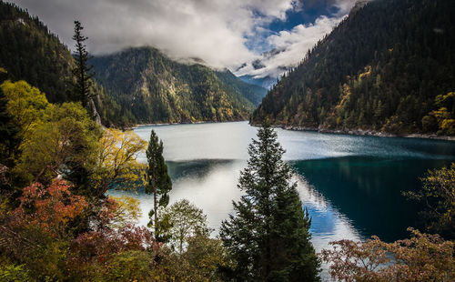 Scenic view of lake by mountains against sky