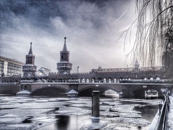 Bridge over river against cloudy sky