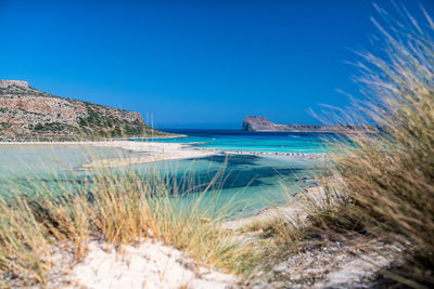 Scenic view of sea against clear blue sky