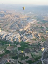 Aerial view of hot air balloon flying over landscape