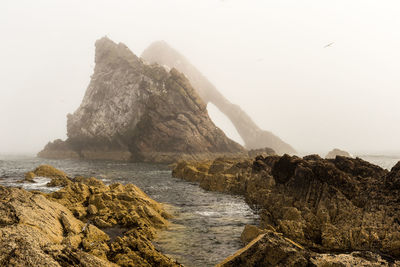 Scenic view of rocky mountains and sea against sky