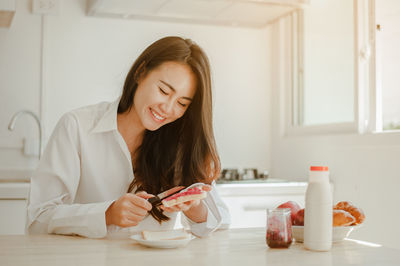 Young woman holding ice cream on table