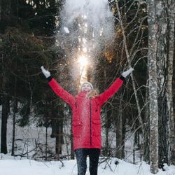 Woman with umbrella standing in snow