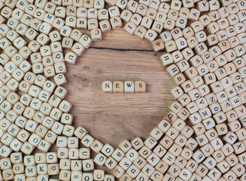 Directly above shot of news text amidst wooden cubes