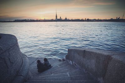 Silhouette of people in water at sunset