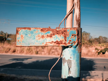 Close-up of rusty metal against blue sky