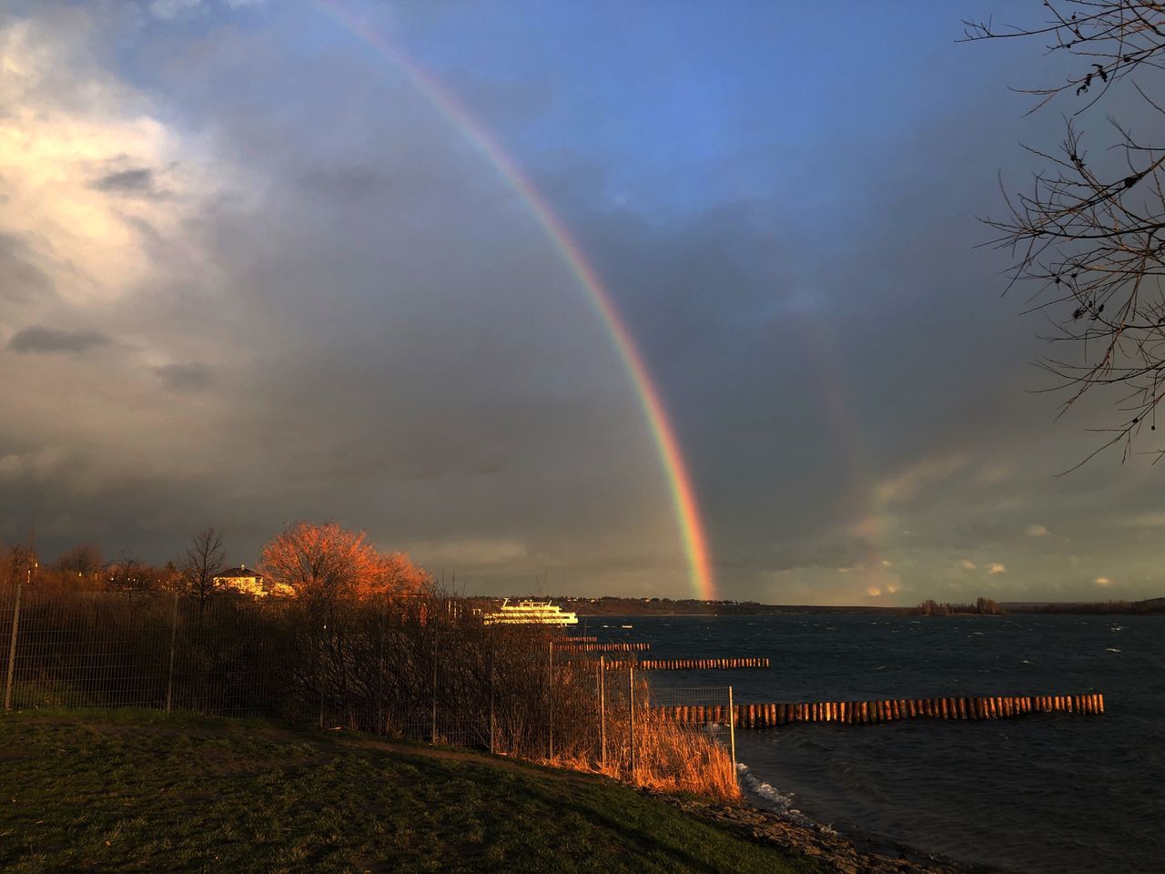 sky, rainbow, cloud - sky, beauty in nature, scenics - nature, nature, tranquil scene, water, tree, tranquility, plant, idyllic, sunset, no people, double rainbow, multi colored, architecture, non-urban scene, outdoors