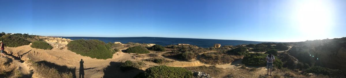 Panoramic view of sea and mountains against clear blue sky