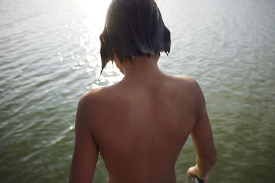 Rear view of boy at water