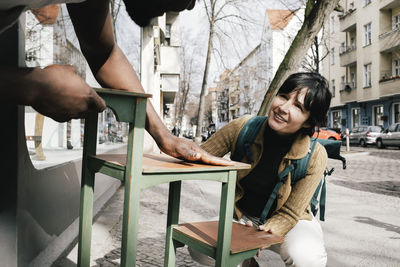 Woman buying upcycled furniture outside store