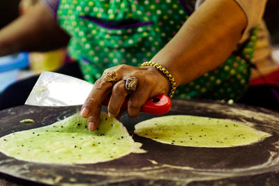 Close-up of woman preparing food in plate