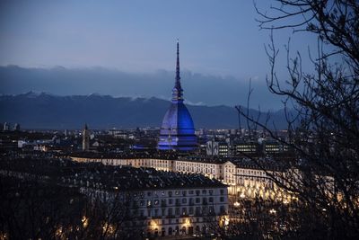 Illuminated buildings in city against sky