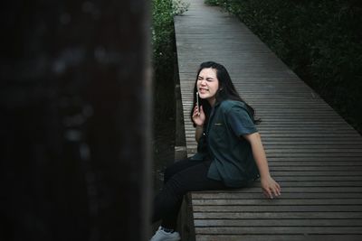 Portrait of a smiling young woman sitting on staircase