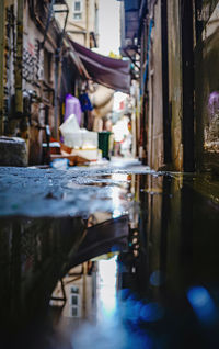 Reflection of old building in canal on wet street in city