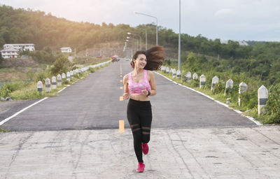 Full length portrait of woman standing on road