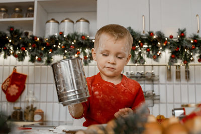 Portrait of boy holding drink on table