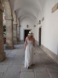 Rear view of woman standing against building