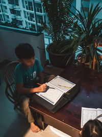 High angle view of boy studying at home