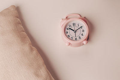 Pillow and alarm clock on a beige background. healthy restful sleep concept.