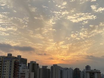 Buildings in city against sky during sunset