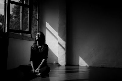 Young woman practicing yoga on floor