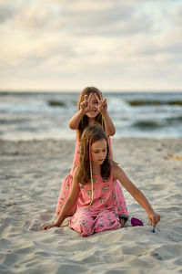 Two sisters playing on the beach at the day time. concept of friendly sister.