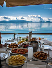 Food on table at restaurant against sea