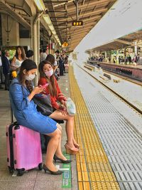 People sitting on railroad station platform