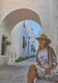 Side view of young woman sitting in tunnel