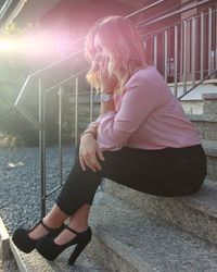 Side view of girl sitting outdoors