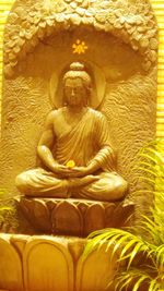Buddha statue on yellow wall