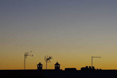 Low angle view of silhouette windmill against sky during sunset