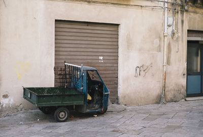 Garbage can on street against building
