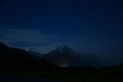 Scenic view of mountains against sky at night