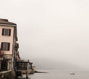 Scenic view of sea by buildings against sky