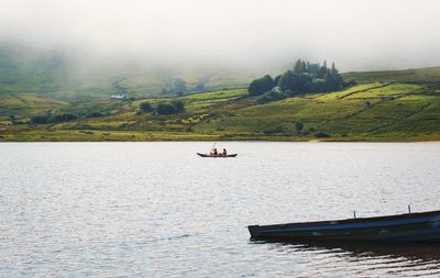 People canoeing on loch na fooey, sandy beach, green mountains, landscape of connemara,county galway